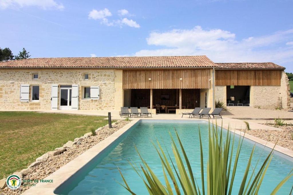une maison avec piscine devant un immeuble dans l'établissement Cottage RG, à Lamothe-Landerron