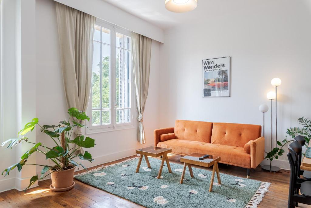 un salon avec un canapé orange et une table dans l'établissement Angie By Terry's Homes, à Cannes