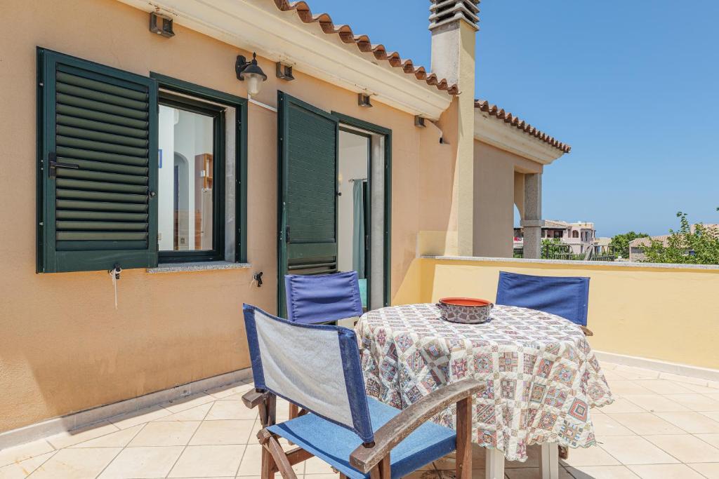 una mesa con 2 sillas y un mantel en el patio en Oltre Casa, en Porto San Paolo