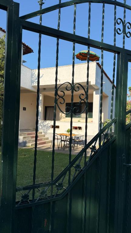 a view of a house seen through a fence at Gerea's Holiday House in Draç