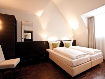 a bedroom with a white bed and a mirror at Art Hotel Lauterbach in Kaiserslautern