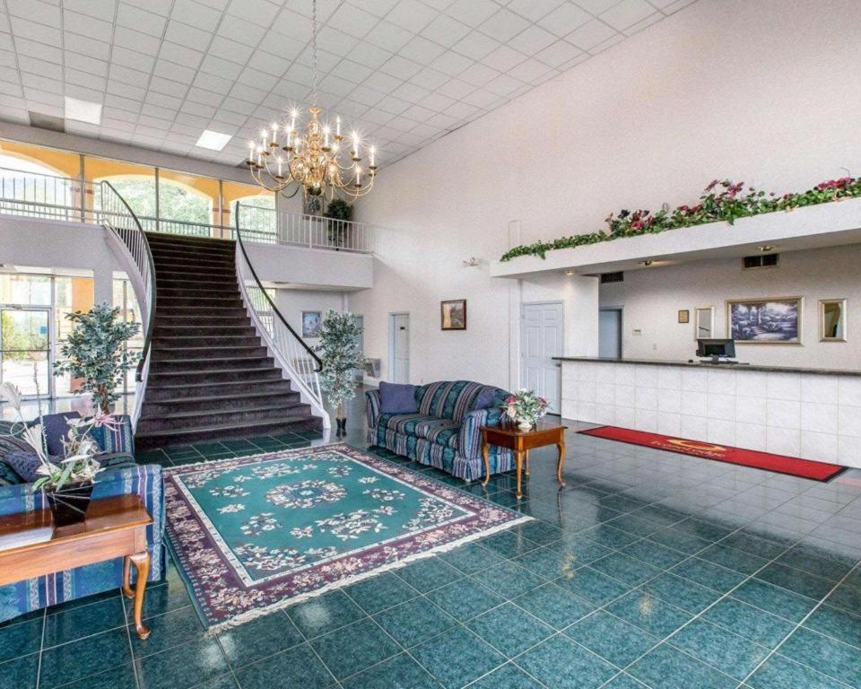 Una sala de estar con un sofá y una escalera. en Econo Lodge Dalton West, en Dalton