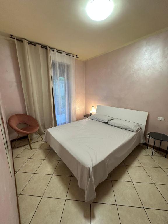 a bedroom with a white bed and a chair at Appartamento vista mare in Grottammare