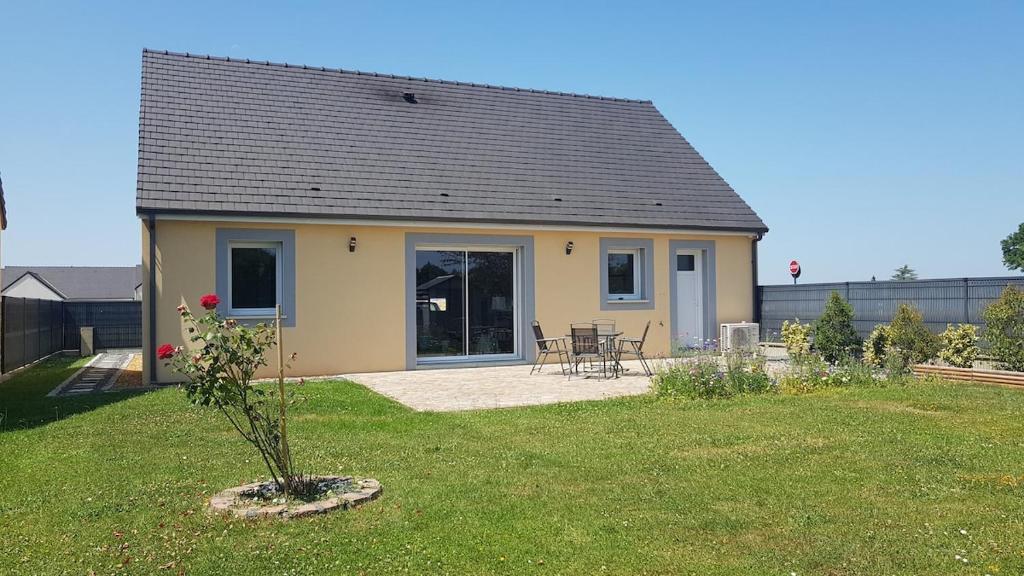 une petite maison avec une table et des chaises dans une cour dans l'établissement Maison au Coeur du Perche Arcisses Margon, à Margon