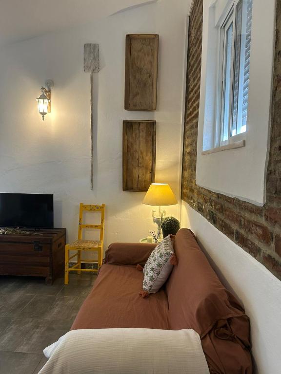 a bedroom with a bed and a tv and a chair at Pé na Terra Terraço in Reguengos de Monsaraz