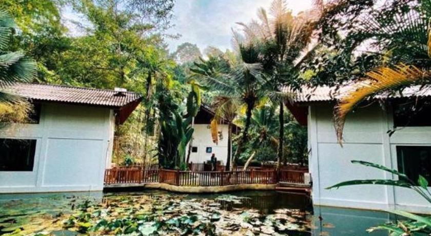 a house with a koi pond in front of it at Bidaisari Resort in Kampong Sum Sum
