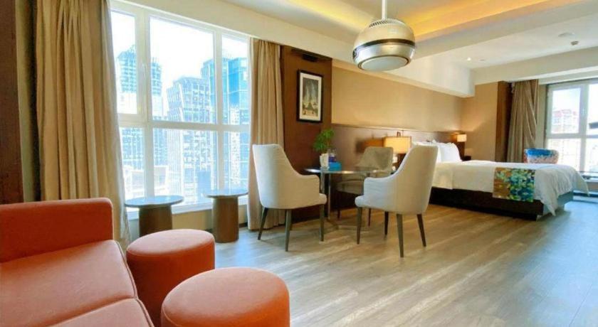 a hotel room with a bed and a table and chairs at Zmax Hotel·Xining Wanda Plaza in Xining