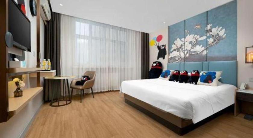 une chambre avec un lit, un bureau et une télévision dans l'établissement Magnotel Business Harbin Railway Station Qiulin Museum Metro Station, à Harbin