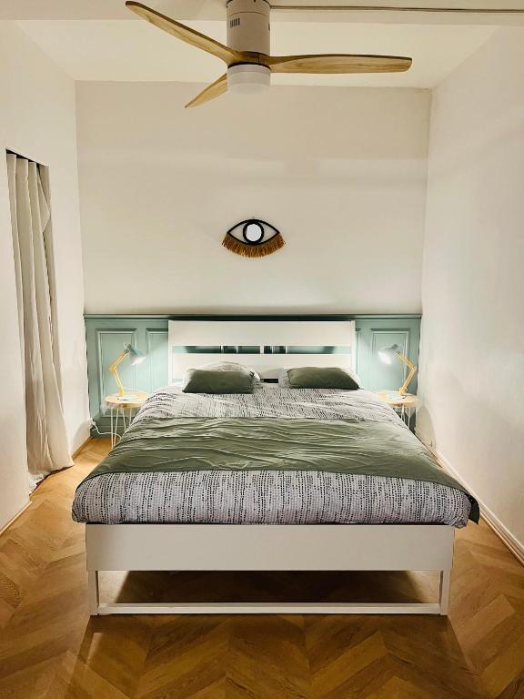 - une chambre dotée d'un lit avec une horloge murale dans l'établissement Appartement Cosy et Calme - Centre historique, à Montpellier