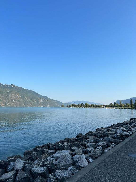 a large body of water with rocks on the shore at Vue Lac in Tresserves