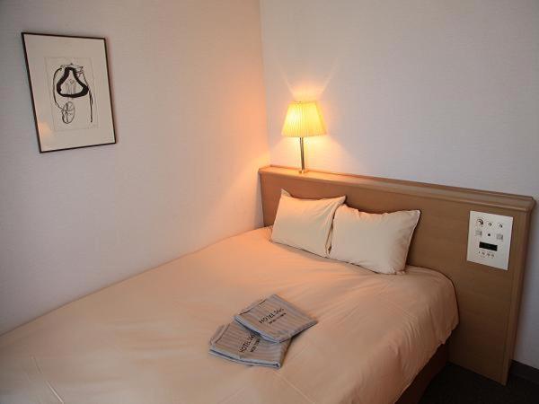 Postel nebo postele na pokoji v ubytování AkishimaStationHotel TOKYO