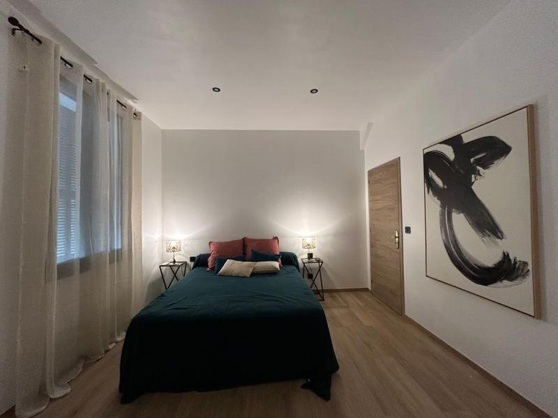 Un dormitorio con una cama en una habitación blanca. en U San Petru -Locations de chambres, en Bains de Guitera