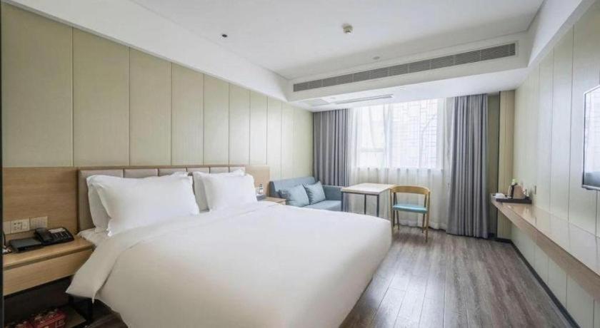 a large white bed in a hotel room at Borrman Hotel Xiamen Xiang'an Maxiang in Xiang'an