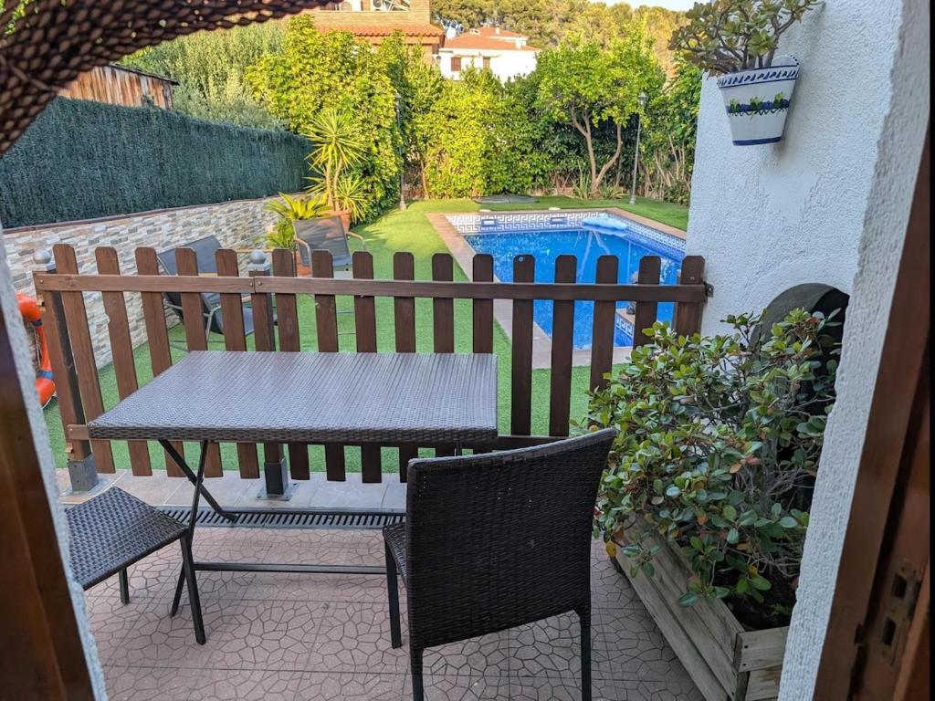 a table and chairs on a patio with a fence at Winahost Apartment la Piscina de Creixell in Creixell