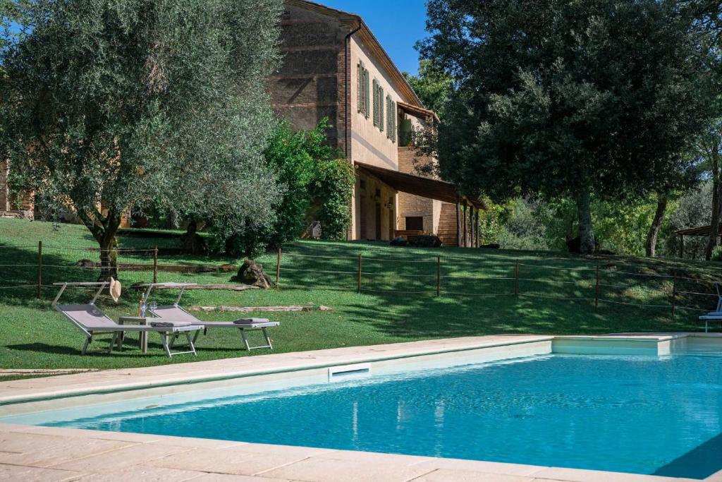 a swimming pool in front of a house at Tuscan Hamlet In Organic Wine Estate in Buonconvento