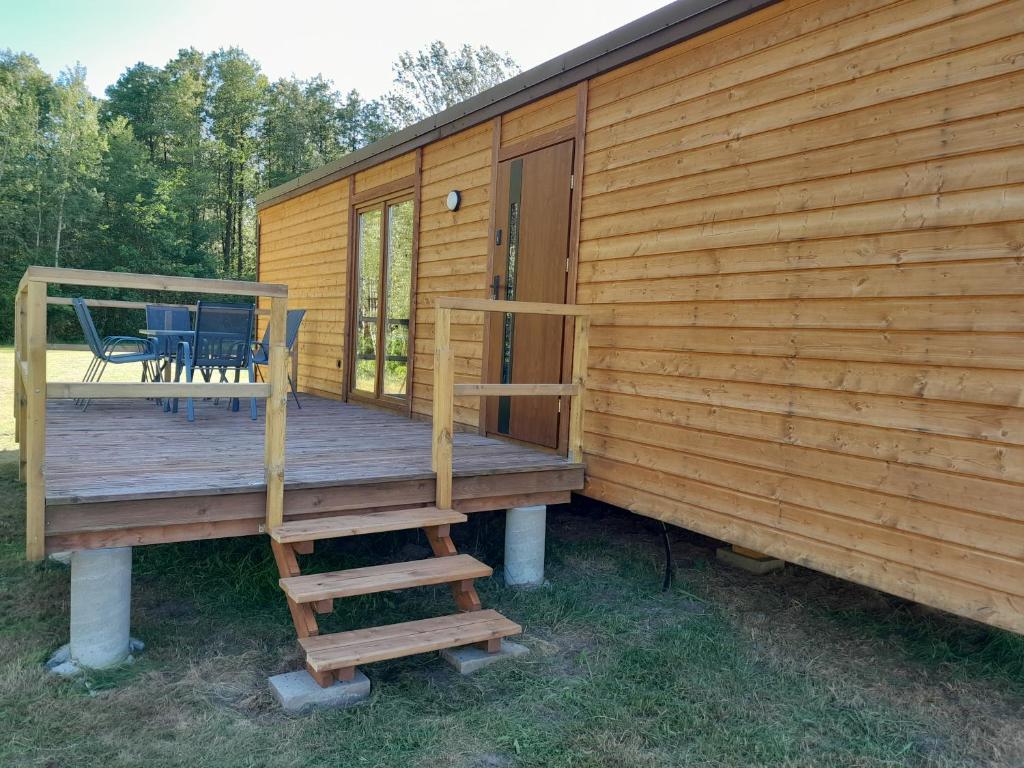 a deck of a cabin with a chair on it at Domki letniskowe Jastrzębna 