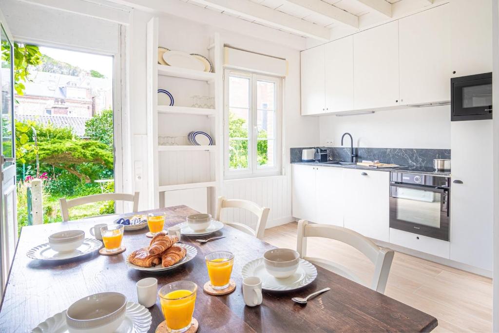 a kitchen with a table with food and orange juice at L'air du Large - 150m plage - Confort in Étretat