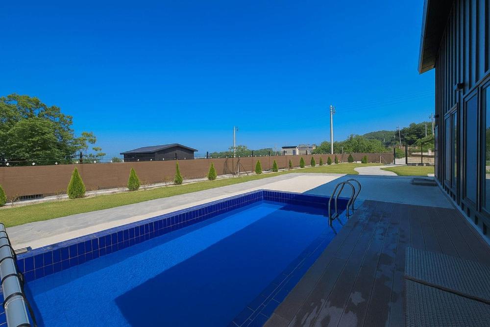 a large blue swimming pool in a house at Daeboodo Podohyangki Pension in Ansan