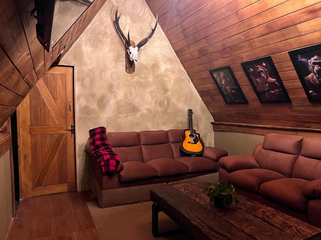 a living room with a couch and a guitar at Rustique Lodge in Nuwara Eliya