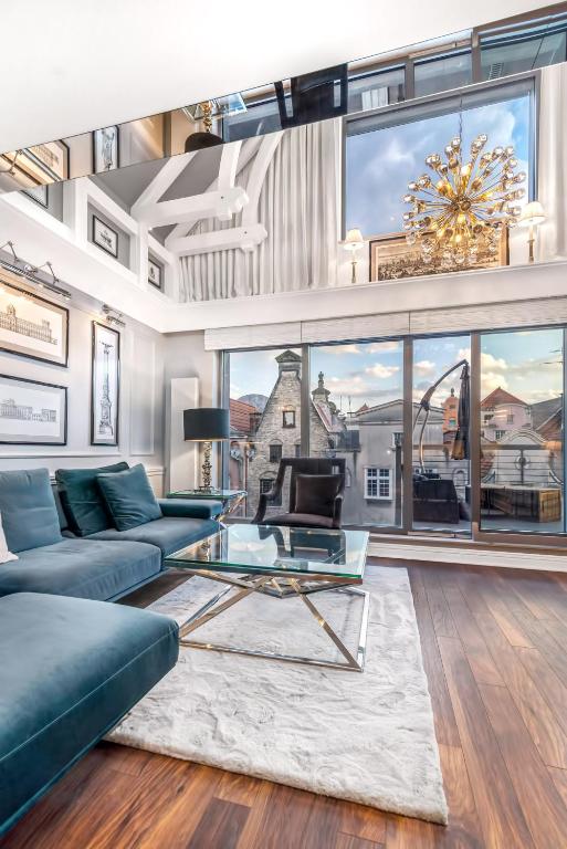 a living room with a blue couch and a glass table at VIU Indigo Apartments in Gdańsk