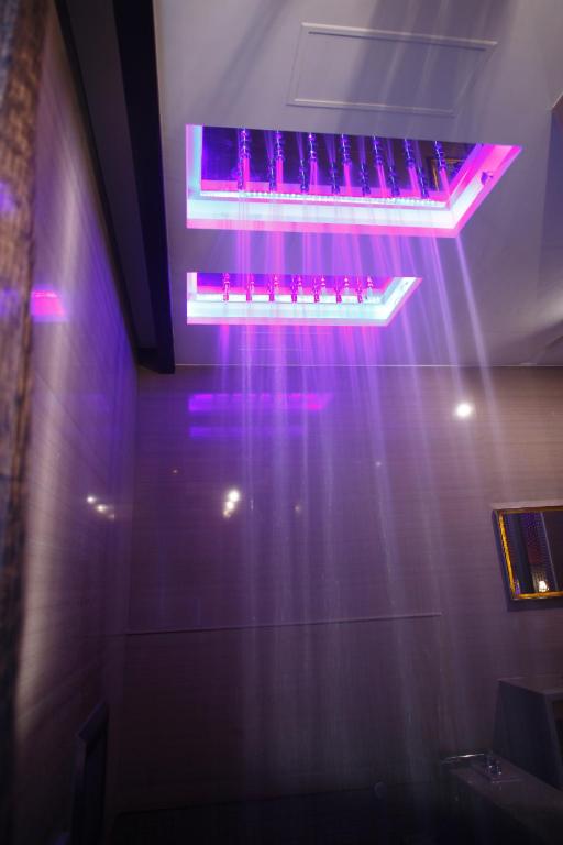 a light hanging from a ceiling with purple lights at Dryad Motel in Tainan