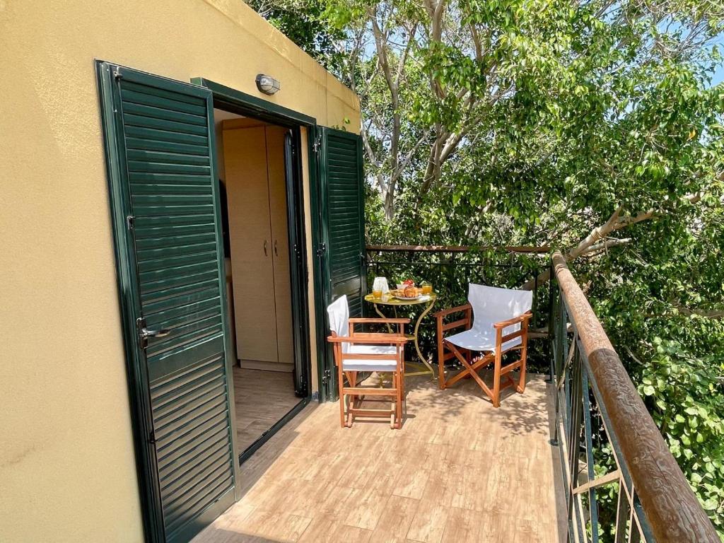 a patio with a table and chairs on a balcony at The Secret Treehouse in Hersonissos