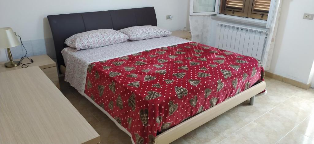 1 dormitorio con 1 cama con manta roja y almohadas en Casa dell'Orto, en La Spezia
