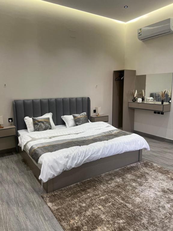 1 dormitorio con 1 cama grande y cabecero gris en شاليه لدن, en Hail