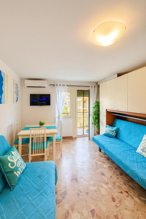 a living room with a blue couch and a table at Casa vacanza 'Note di mare' in Torvaianica