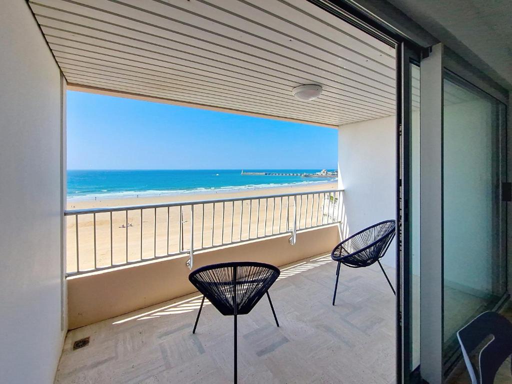 d'un balcon avec des chaises et une vue sur la plage. dans l'établissement Studio rénové avec terrasse sud et vue mer - FR-1-331-54, à Les Sables-dʼOlonne