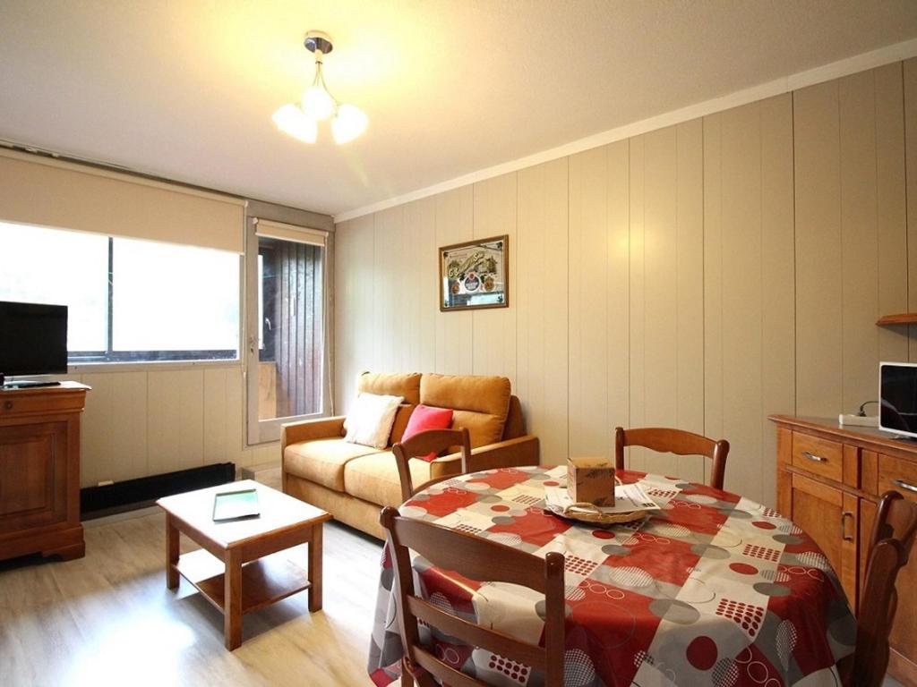 un salon avec une table et un canapé dans l'établissement Mont-Dore : T2 avec balcon et WIFI - FR-1-608-58, à Le Mont-Dore