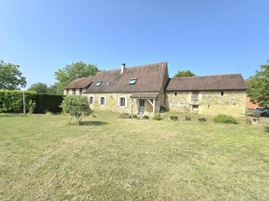 une vieille maison en pierre avec une grande cour dans l'établissement Maison rustique près de Sarlat: 4 chambres, jardin, Wi-Fi, activités nature, ferme et lac à proximité - FR-1-616-186, à Tamniès