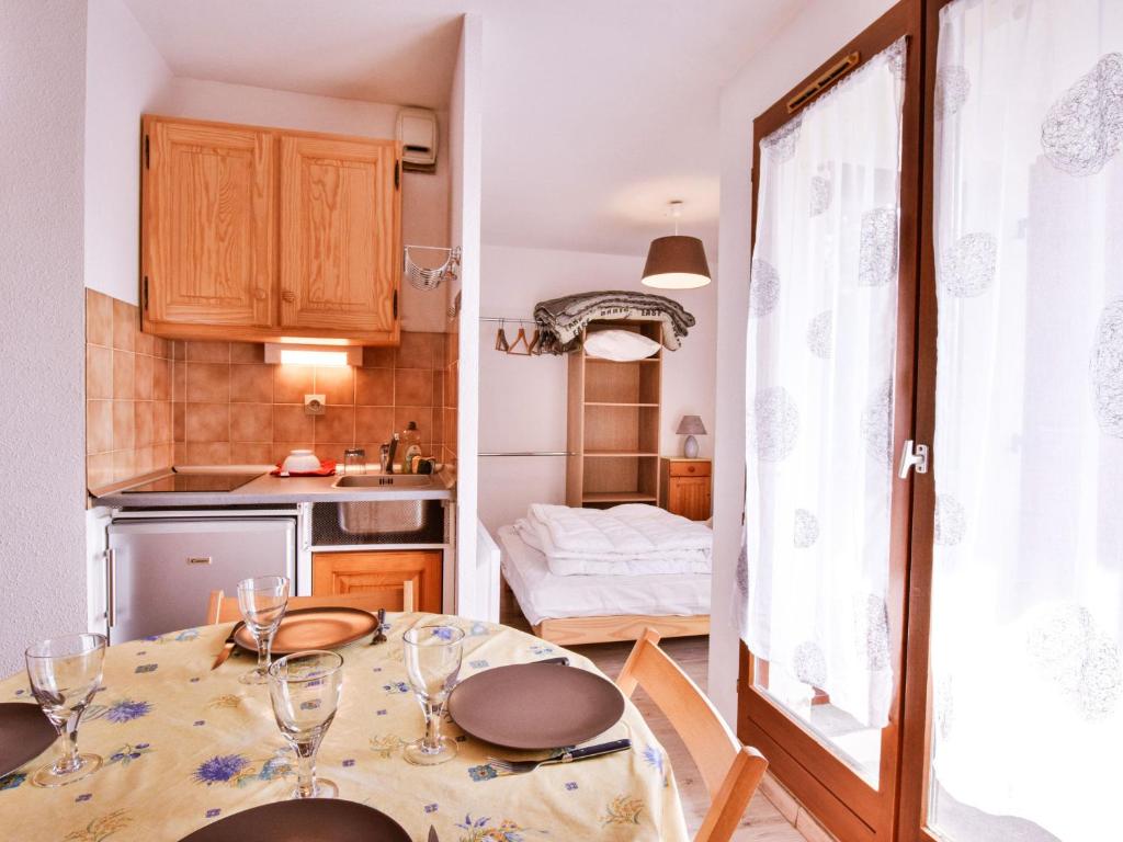 - une petite cuisine avec une table et des verres à vin dans l'établissement Charmant T2 de 23m² à Bernex, proche pistes et randonnées, avec balcon et tout équipé - FR-1-498-34, à Bernex