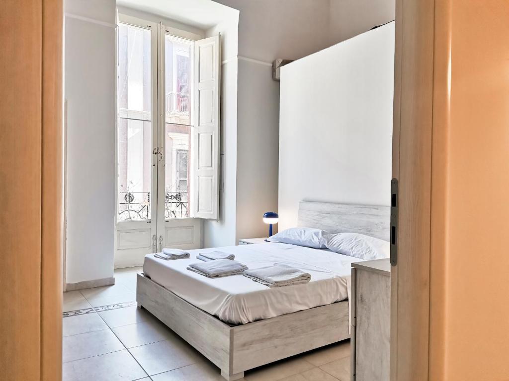 ein Schlafzimmer mit einem Bett und einem großen Fenster in der Unterkunft Al Donà in Bari