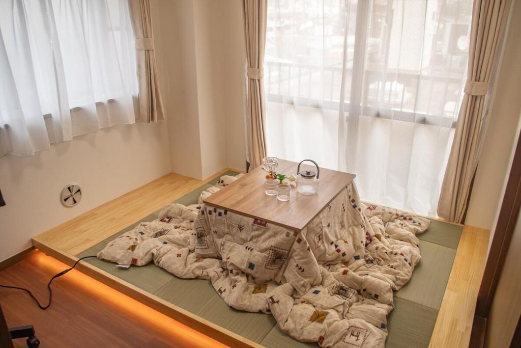 a room with a table on top of blankets at Direct to Shinjuku Two bedrooms Higashi-Nakano Station Free luggage storage in Wada