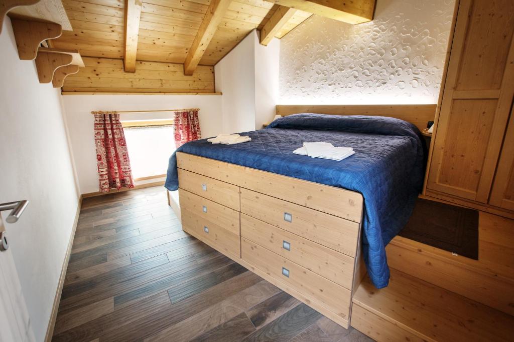 ein kleines Schlafzimmer mit einem Bett in einer Hütte in der Unterkunft Da Cinto in Paluzza