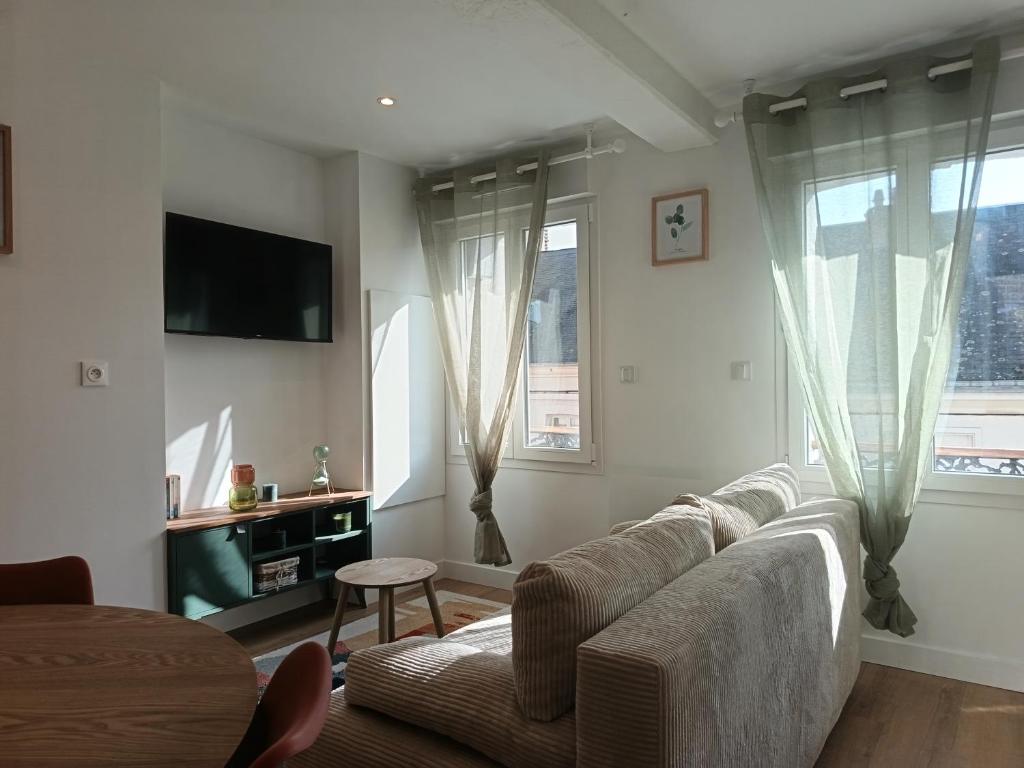 a living room with a couch and a tv at L'Abri de Marée Duplex - La Marée Verte" in Saint-Valéry-en-Caux