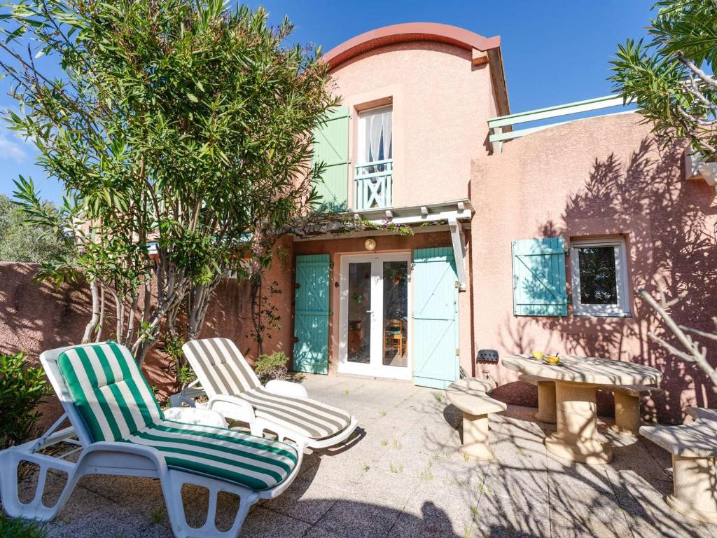 deux chaises et une table devant une maison dans l'établissement Pavillon 3 pièces proche plage du Grazel, climatisation, parking privé - FR-1-409-84, à Gruissan