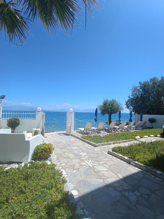 a pathway with chairs and the ocean in the background at Villa Constantina Apartments in Liyiá
