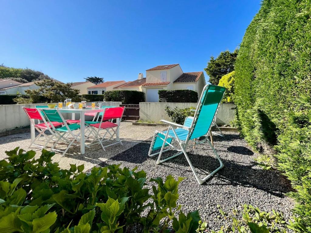 - une table et des chaises dans l'arrière-cour d'une maison dans l'établissement Maison Confortable à 300m de la Plage des Dunes avec Jardin et Parking Privé - FR-1-231-188, à Bretignolles-sur-Mer