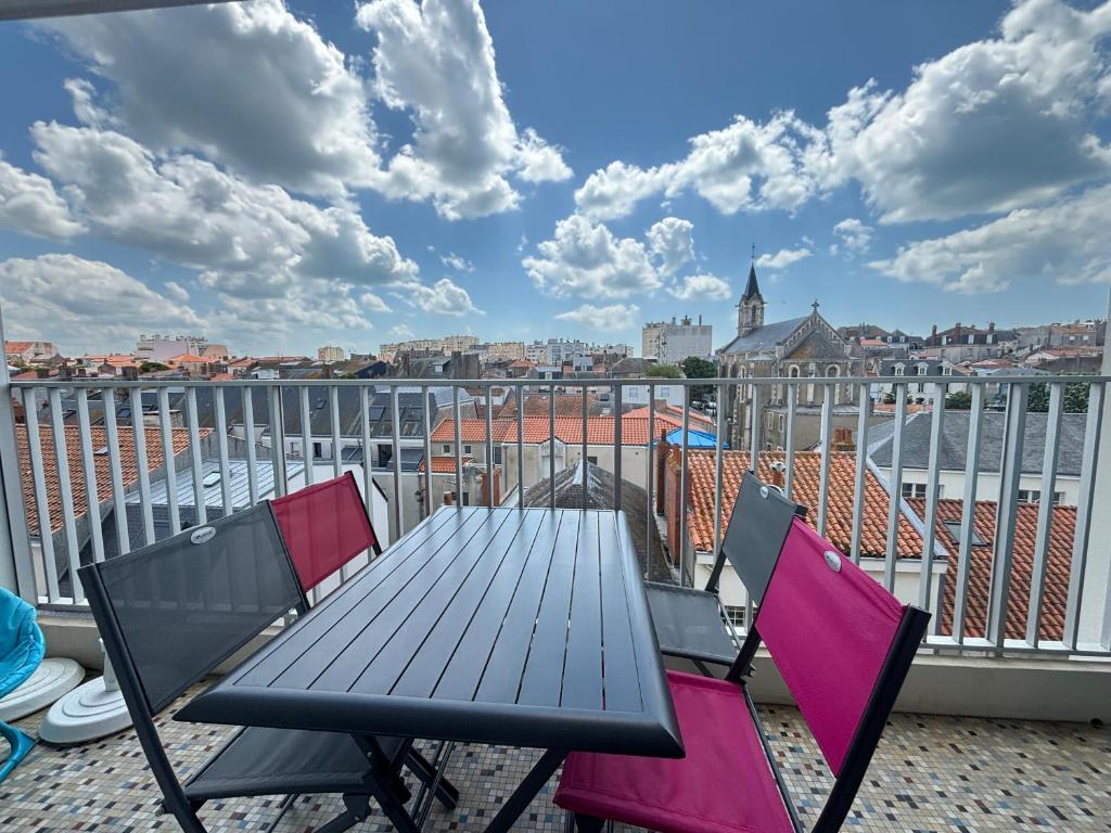 une table et des chaises sur un balcon avec vue dans l'établissement Appartement Moderne Centre-Ville, Proche Plage, 5 Couchages, Parking Privé - FR-1-197-555, à Les Sables-dʼOlonne
