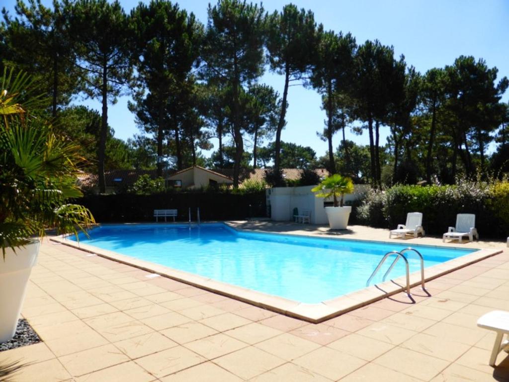 une piscine dans une cour avec un patio dans l'établissement Location Vacances La Palmyre - Maison 4/5 pers. avec Piscine, Proche Plages & Commerces. - FR-1-705-6, à La Palmyre