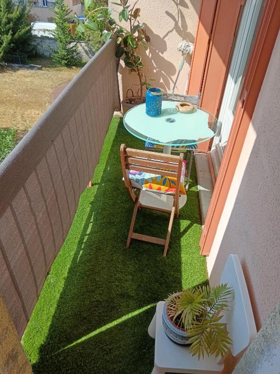 Elle comprend une petite terrasse avec une table et une chaise. dans l'établissement GRAND PARIS, private parking, balcony and metro, 24 hours self checking, à Bondy