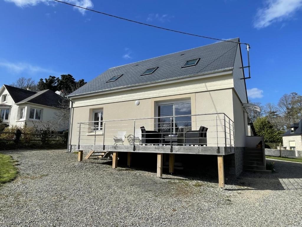 une maison avec une grande terrasse et un solarium dans l'établissement Maison rénovée proche mer 7 pers., jardin, wifi et ping-pong, 3 chambres, 2 salles d'eau - FR-1-361-426, à Carolles