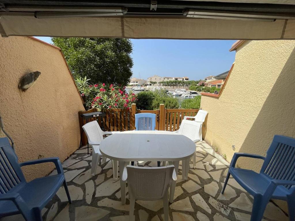 une table blanche et des chaises sur une terrasse dans l'établissement Charmant Pavillon Familial avec Terrasse et Mezzanine - Proche Plage - Saint-Cyprien Plage - FR-1-106-86, à Saint-Cyprien