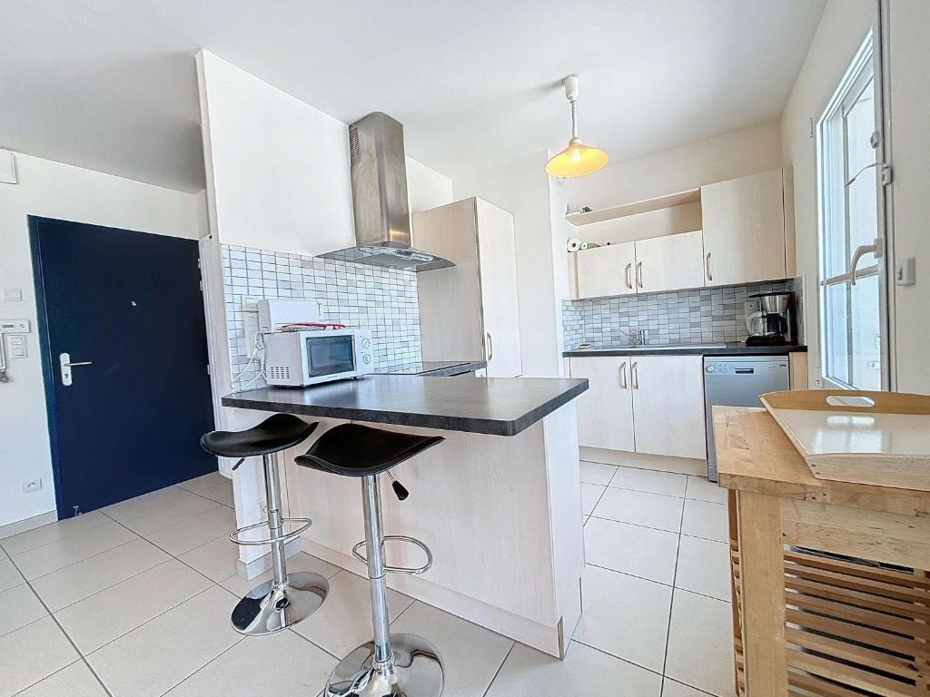 une cuisine avec un comptoir avec un micro-ondes dessus dans l'établissement Appartement 3P avec Ascenseur, Parking et Proche Plage à Granville - FR-1-361-59, à Granville