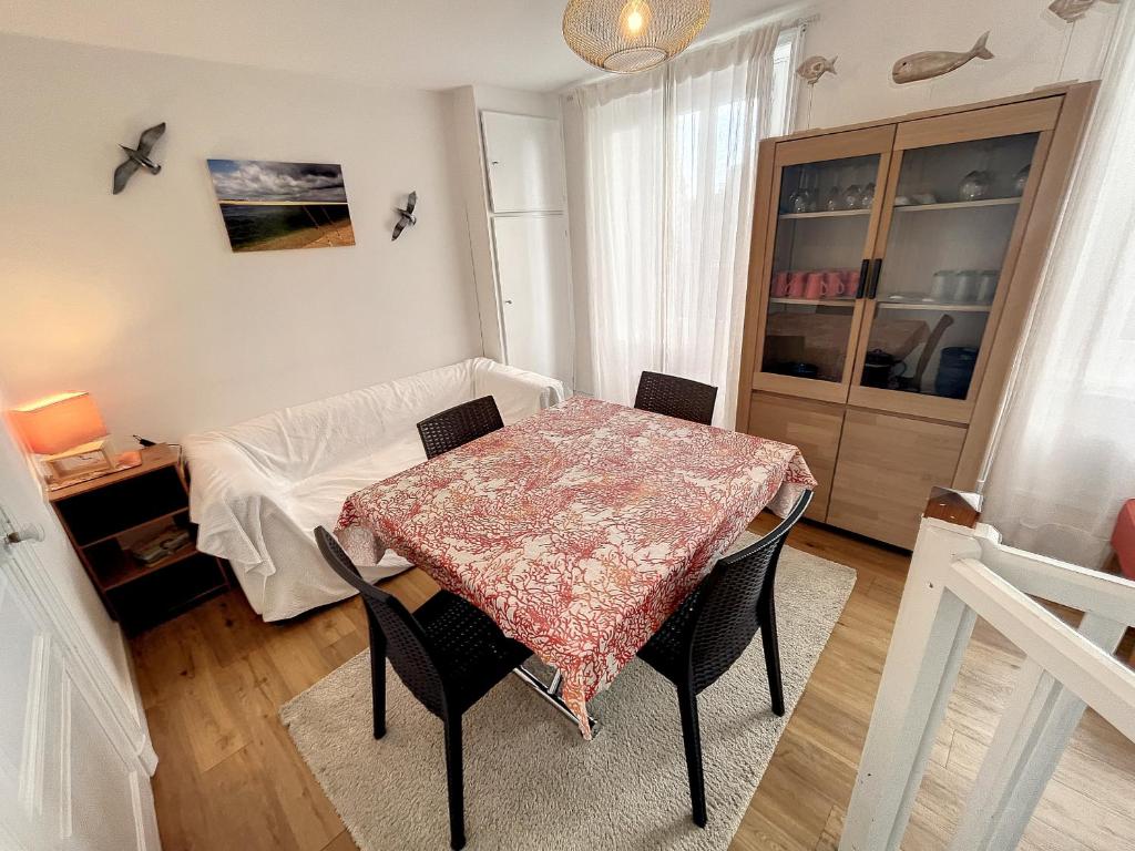 une salle à manger avec une table et des chaises dans une pièce dans l'établissement Duplex Atypique avec Terrasse à 400m de la Plage et du Centre - FR-1-361-333, à Granville