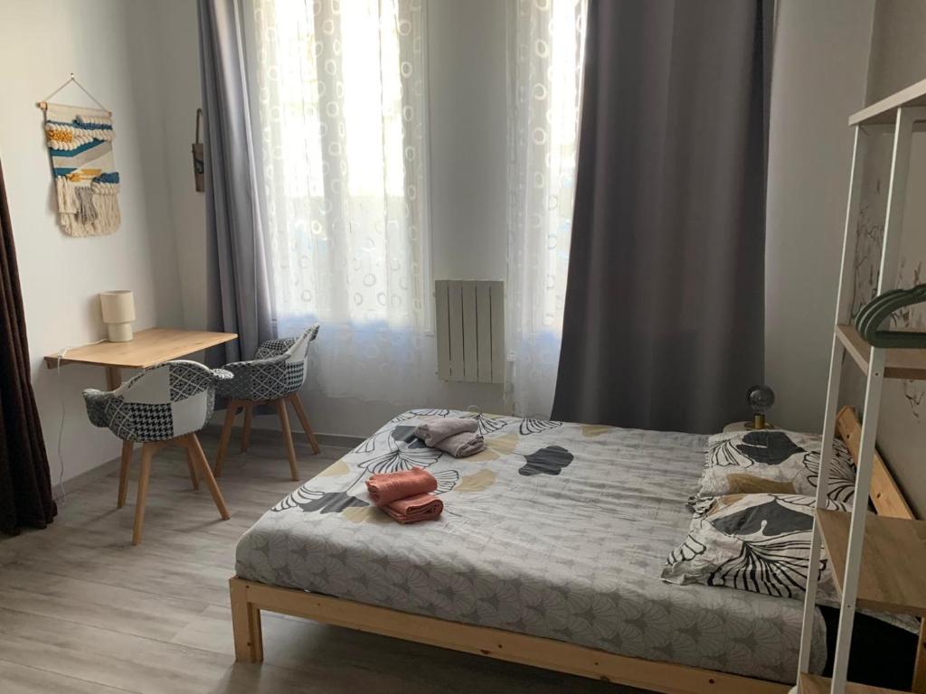 a bedroom with a bed and a table and chairs at Charmant studio cosy à 5 min du centre d'Épernay in Épernay