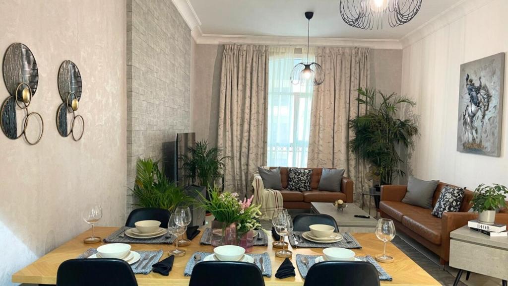 a living room with a table and a couch at Yas Amazon - Stylish 1BR Apartment on Yas Island, Near Yas Mall in Abu Dhabi