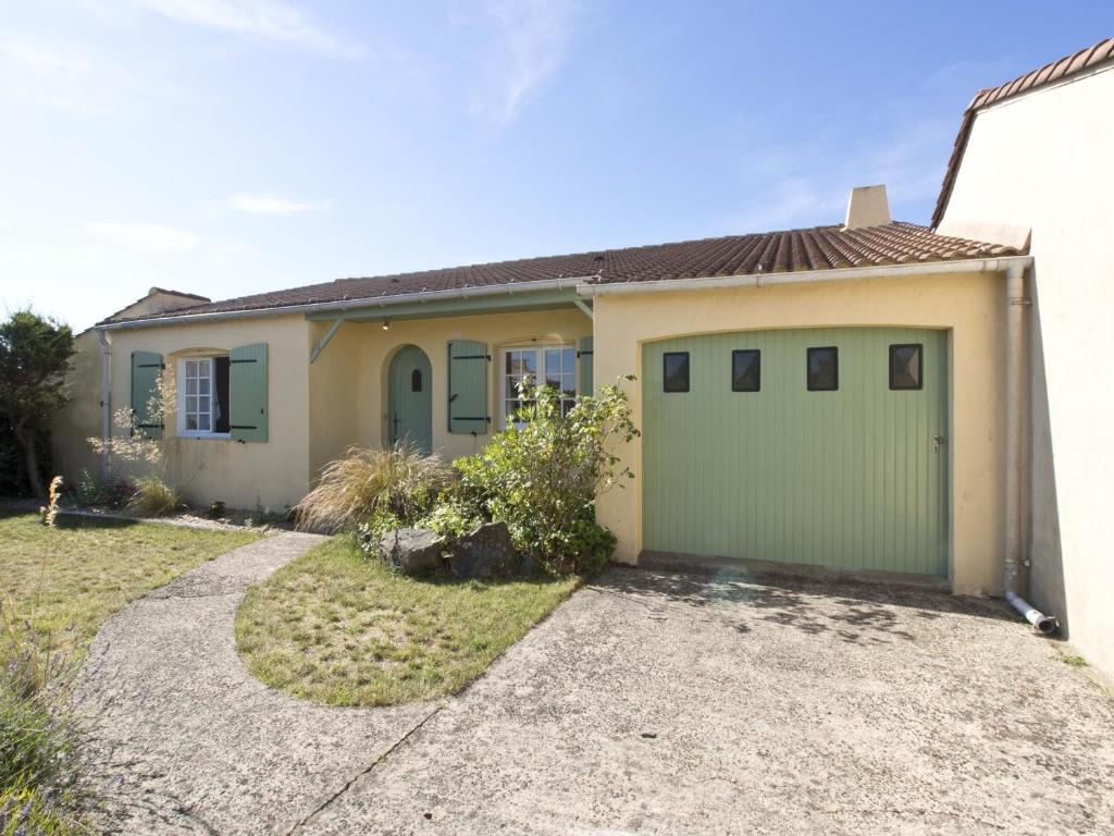 une maison avec un garage vert dans l'établissement Maison T5 à 800m de la plage avec jardin, terrasse et piste cyclable - La Chaume, Les Sables-d'Olonne - FR-1-92-706, à Les Sables-dʼOlonne